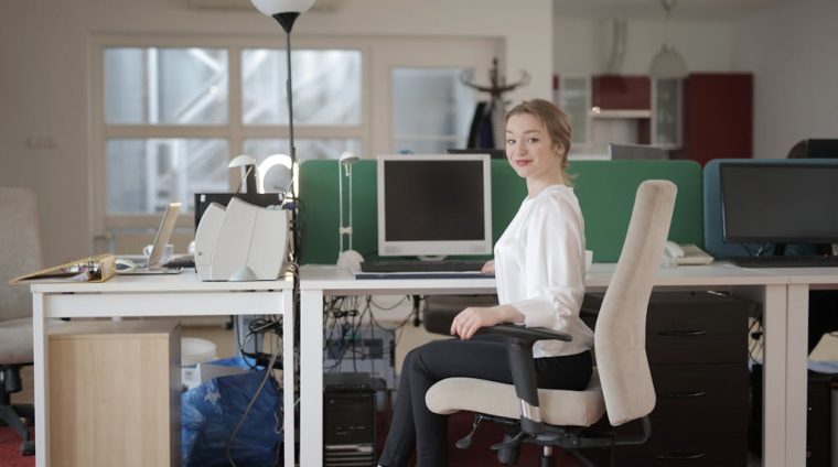 Elegant female employee sitting on chair in modern workplace