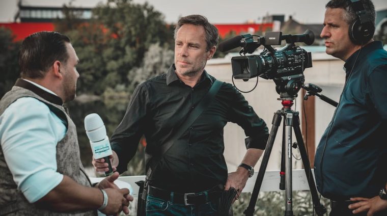 Man Holding Microphone While Talking to Another Man