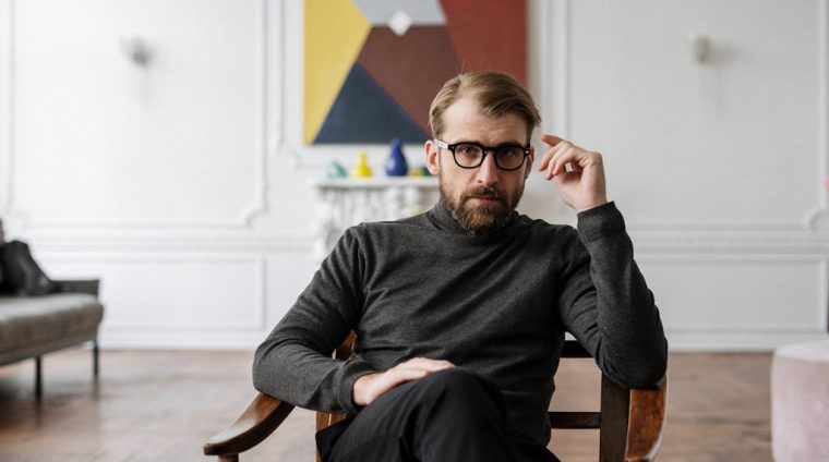 Man in Black Sweater Sitting on Brown Wooden Chair