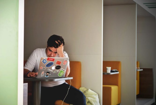 Man in White Shirt Using Macbook Pro