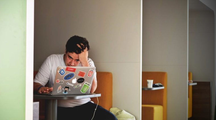 Man in White Shirt Using Macbook Pro