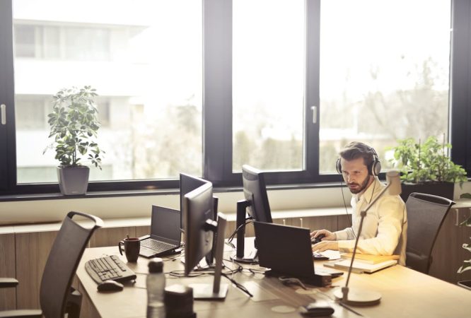 Man With Headphones Facing Computer Monitor