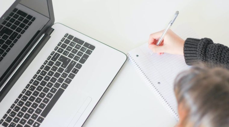 Person Writing on Notebook