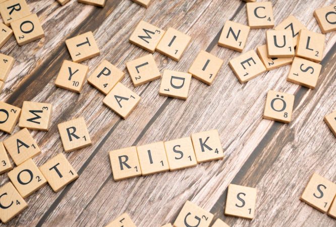 Scrabble letters spelling risk on a wooden table