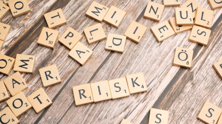 Scrabble letters spelling risk on a wooden table