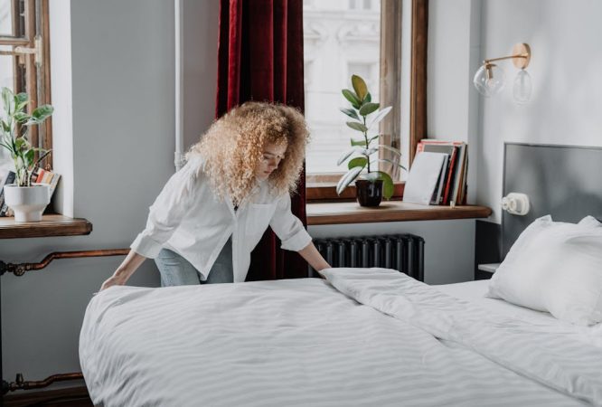 Woman in White Long Sleeve Shirt Sitting on Bed