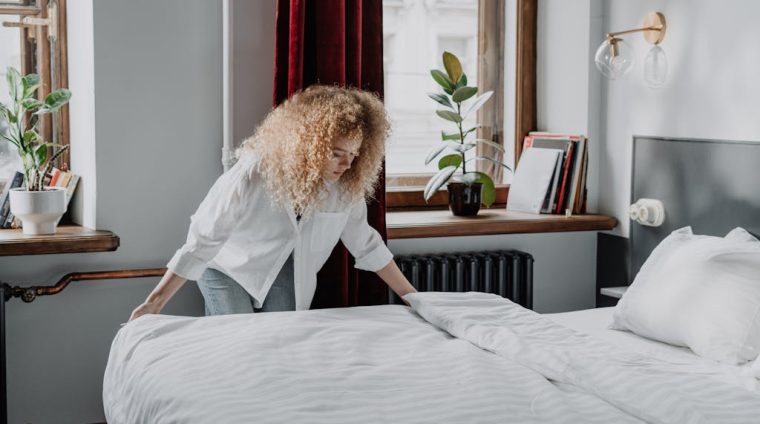 Woman in White Long Sleeve Shirt Sitting on Bed