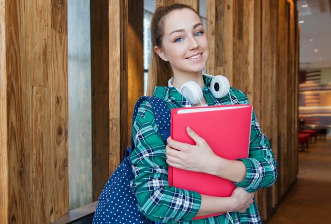 Woman Standing in Hallway While Holding Book