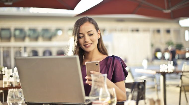 Woman Wearing Purple Shirt Holding Smartphone White Sitting on Chair